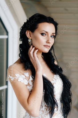 portrait of a beautiful bride with dark long hair with beautiful earrings