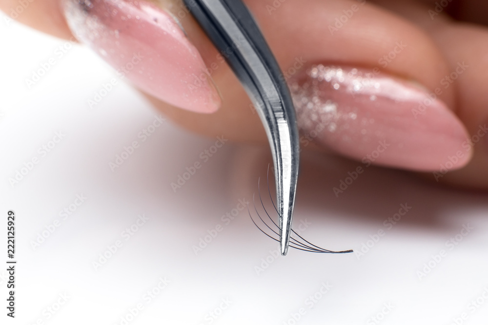 Closeup eyelash extension tweezers tools on white background. Artificial lashes 4D. Closeup eyelash extension tweezers tools on white background. Artificial lashes 4D.