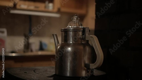 A simmering coffee pot on a wood stove. photo