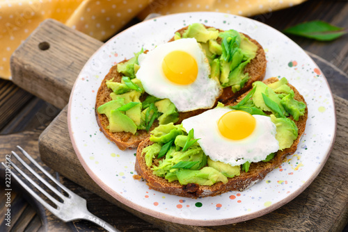 avocado quail egg sandwiches in a plate on a wooden background