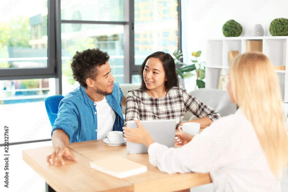 Happy interracial couple with real estate agent in office Happy interracial couple with real estate agent in office