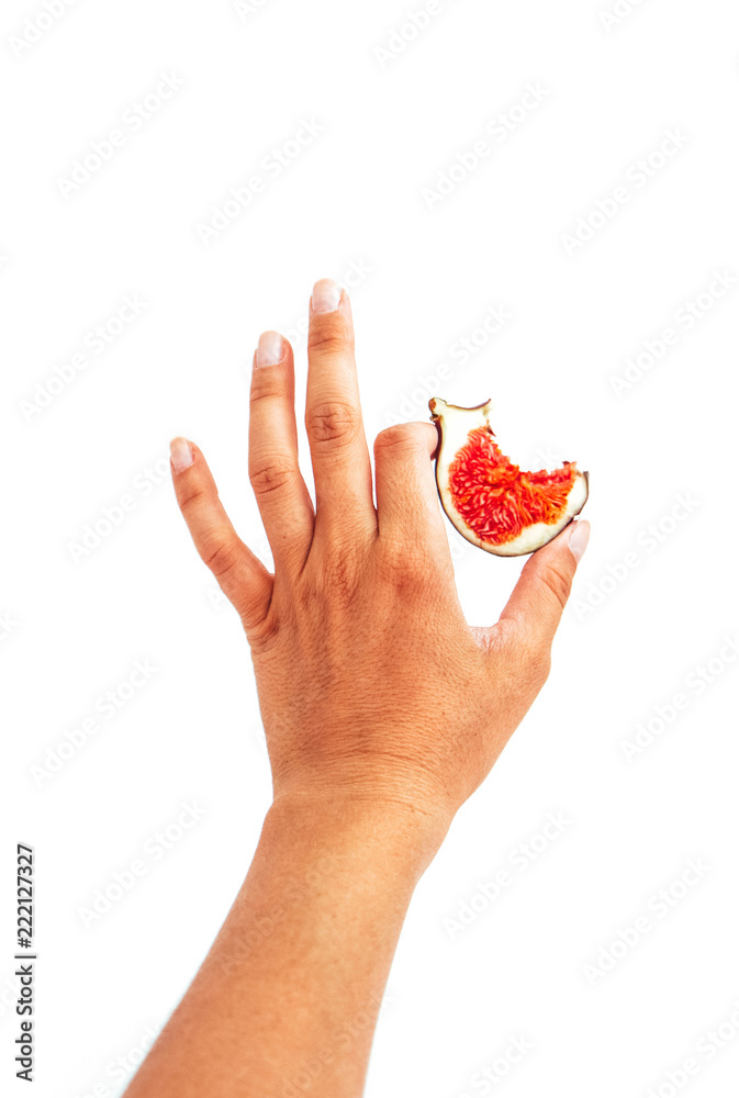 Ripe blue fig in a hand with bite, isolated on white background. Woman hand holding and showing a half of purple fig fruit. Ripe blue fig in a hand with bite, isolated on white background. Woman hand holding and showing a half of purple fig fruit.