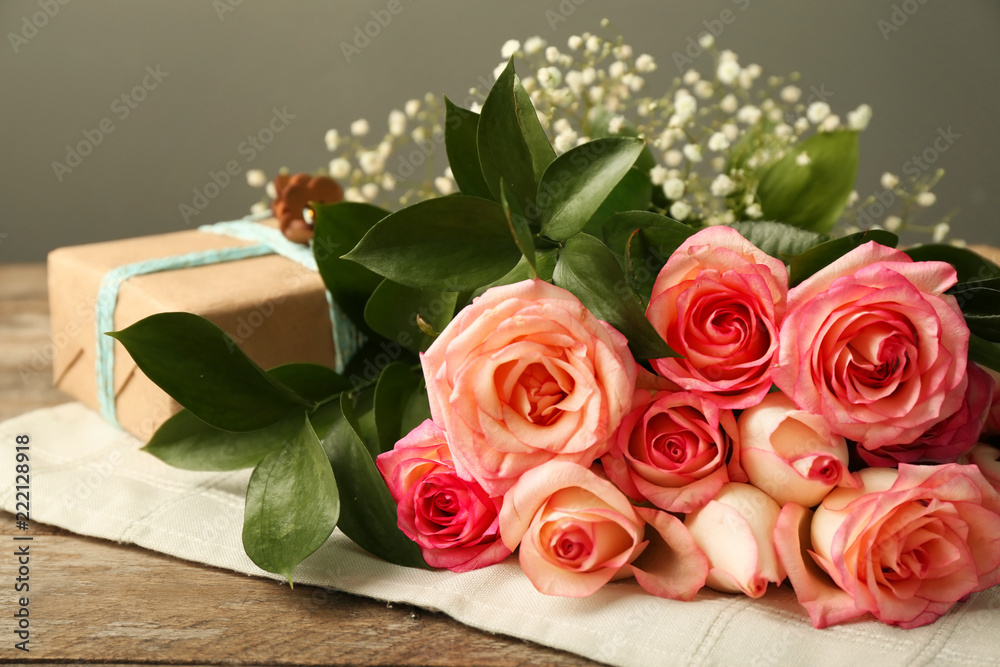 Beautiful roses with gift box on wooden table Beautiful roses with gift box on wooden table