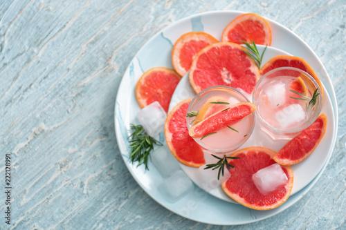 Fresh grapefruit cocktail with rosemary in glasses on plates