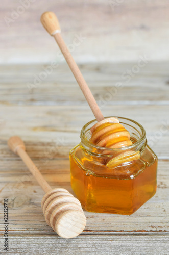 Honig in Glass mit holzen Honiglöffel. Vertikal Ausrichtung auf dem Tisch. photo