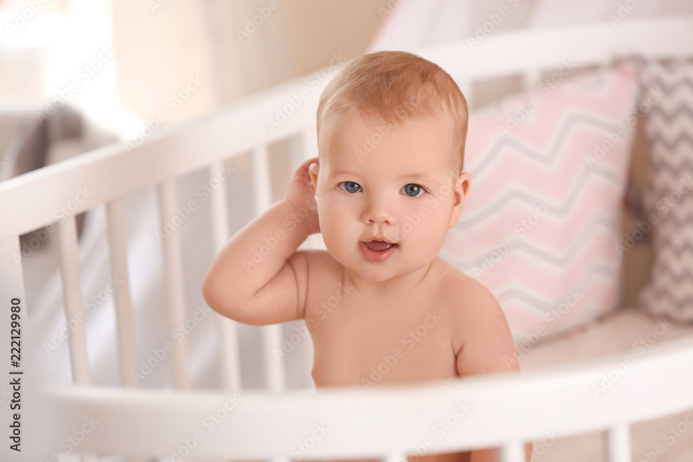 Cute little baby sitting in crib at home Cute little baby sitting in crib at home