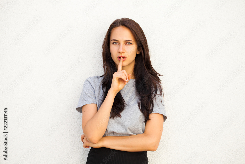 Young beautiful woman has put forefinger to lips as sign of silence Young beautiful woman has put forefinger to lips as sign of silence