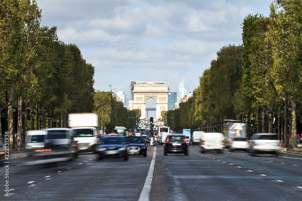 Close-up image of the Arc du Triomphe and traffic on the Champs-Elysees with La Defense in the background in Paris, France, on April 15, 2014
