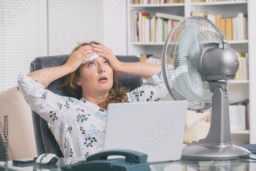 Woman suffers from heat in the office or at home