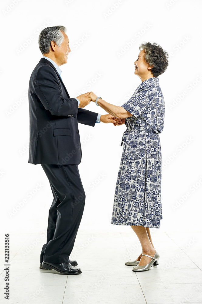 Grandfather and grandmother hand in hand together dancing cheerfully in white background