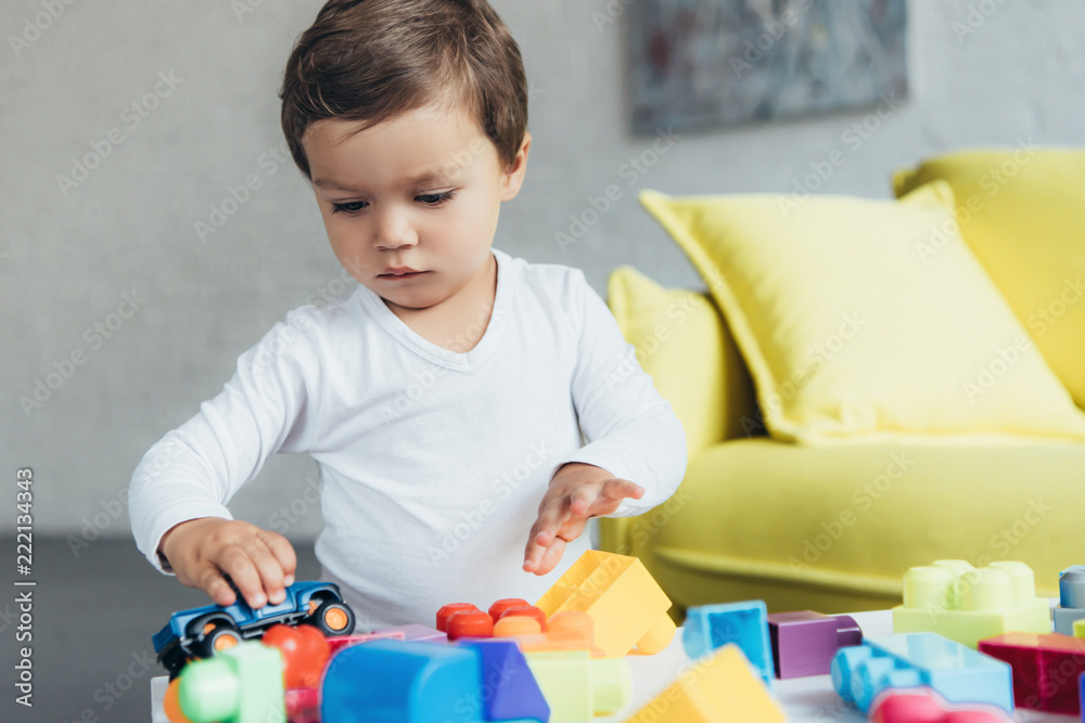cute kid playing with toy car and colorful constructor blocks at home cute kid playing with toy car and colorful constructor blocks at home