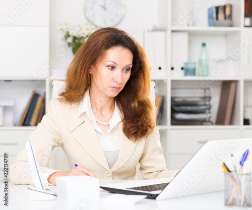 Businesswoman is working with laptop and papers