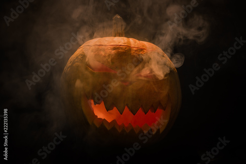Helloween pumpkin with smoke in eyes on black