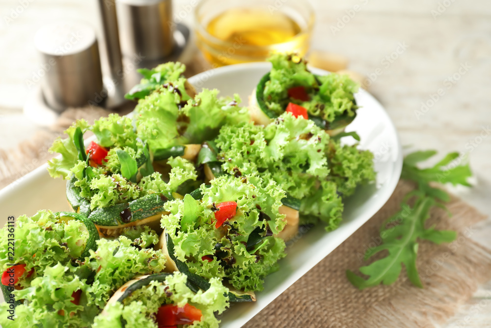 Tasty zucchini rolls with lettuce on plate Tasty zucchini rolls with lettuce on plate