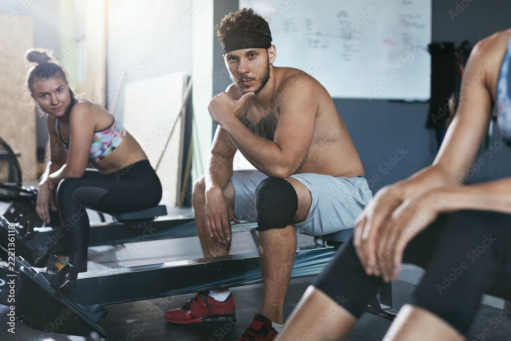 Crossfit. People Exercising On Rowing Machine In Training Gym Crossfit. People Exercising On Rowing Machine In Training Gym