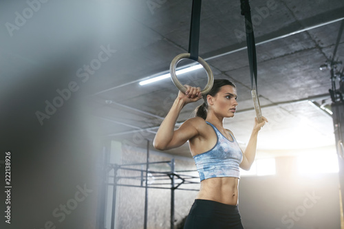 Fitness Woman Training With Gymnastics Rings At Crossfit Gym