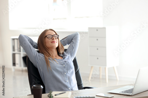 Young businesswoman relaxing at workplace in office photo