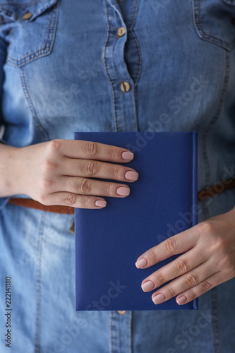 Woman with professional manicure holding notebook, closeup