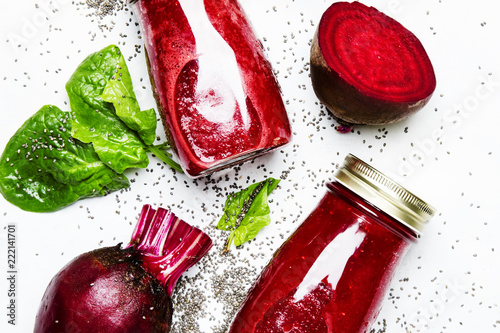 Delicious beetroot smoothies in glass bottles with chia on white food background, top view