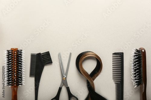 Professional hairdresser's set with strands of hair on light background