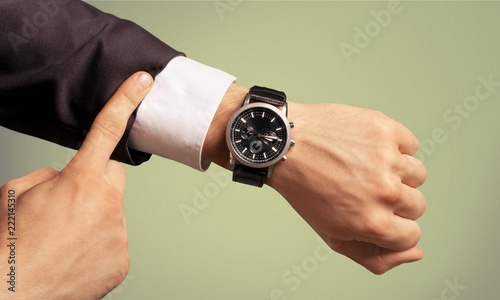Businessman pointing at hand watch on white