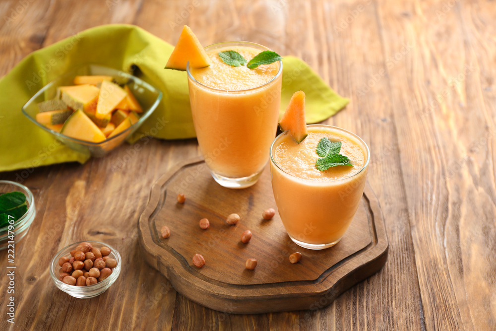 Glasses with tasty melon smoothie on wooden table Glasses with tasty melon smoothie on wooden table