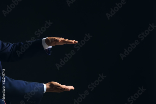 Businessman holding something on dark background