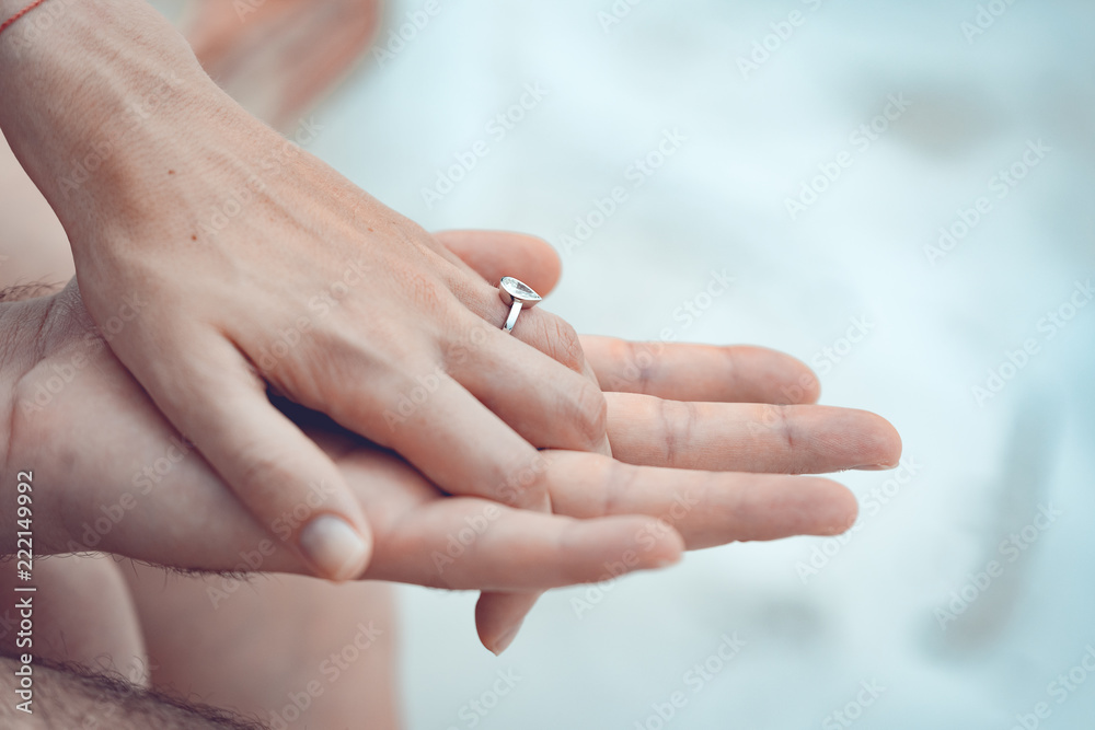 Engagement at the beach of tropical island. Close up of couple hands with silver ring on the finger. Engagement at the beach of tropical island. Close up of couple hands with silver ring on the finger.
