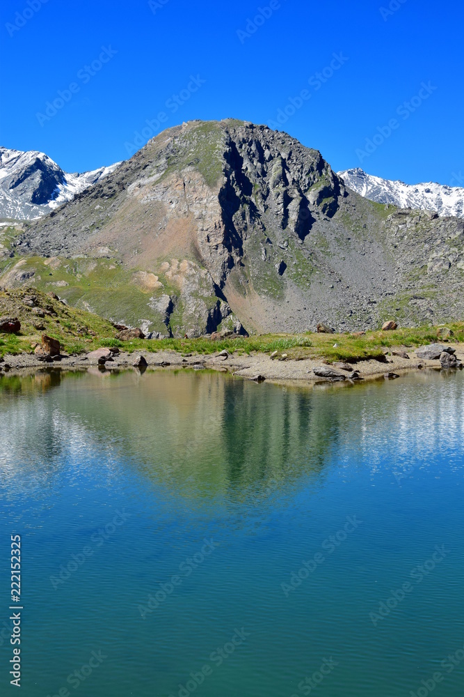 Gebirgssee in Südtirol mit Spiegelung der Bergkette