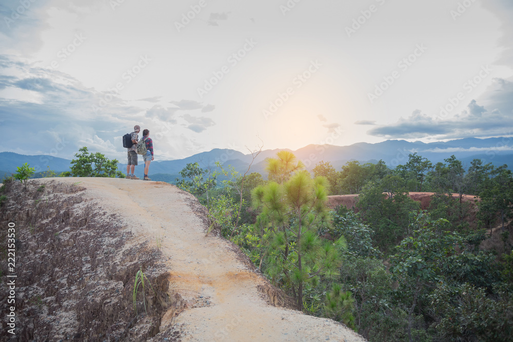 Hikers with backpacks relaxing on top of a hill. Traveling along mountains and coast, freedom and active lifestyle concept