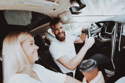 Man Is Driving A Tesla Car. Girl At Front Seat. photo