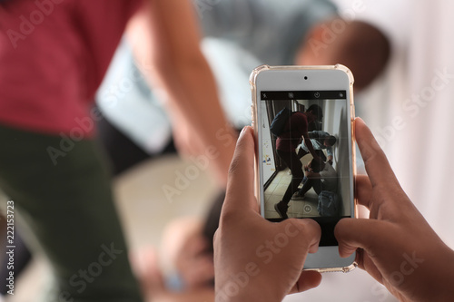 Teenager taking video of bullying boy with mobile phone at school, closeup photo
