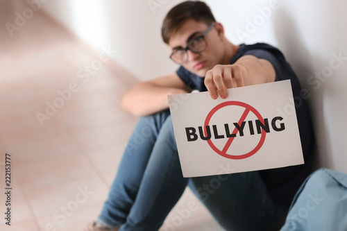 Teenage boy holding sheet o...