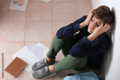 Sad teenage boy sitting on ...