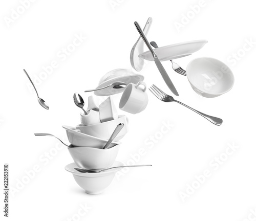 Falling dishes with cutlery on white background