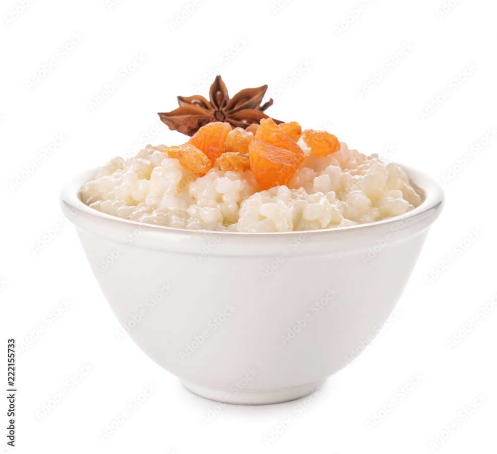 Delicious rice pudding with dried fruits and anise in bowl on white background Delicious rice pudding with dried fruits and anise in bowl on white background