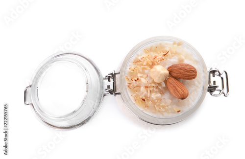 Delicious rice pudding with nuts in jar on white background