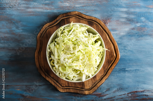 Bowl with shredded cabbage on wooden board