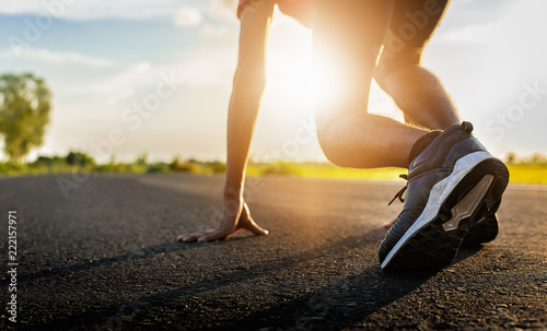 Athlete man in running start pose on the road.