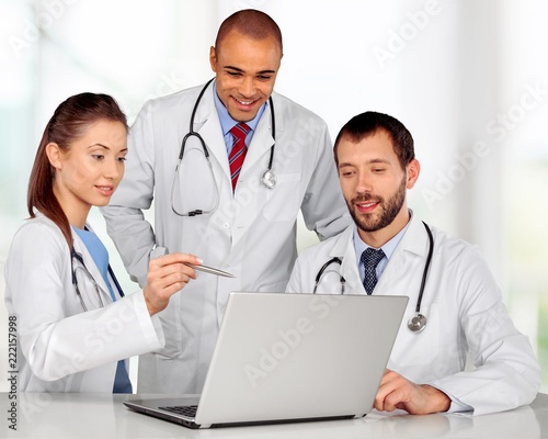 Doctors team talking expertise in hospital by laptop