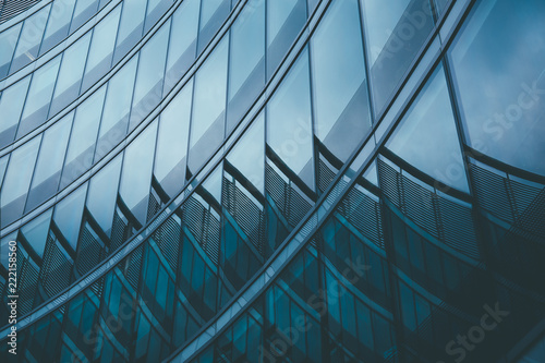Abstract business modern city urban futuristic architecture background. Real estate concept, motion blur, reflection in glass of high rise skyscraper facade, toned blue picture with bokeh