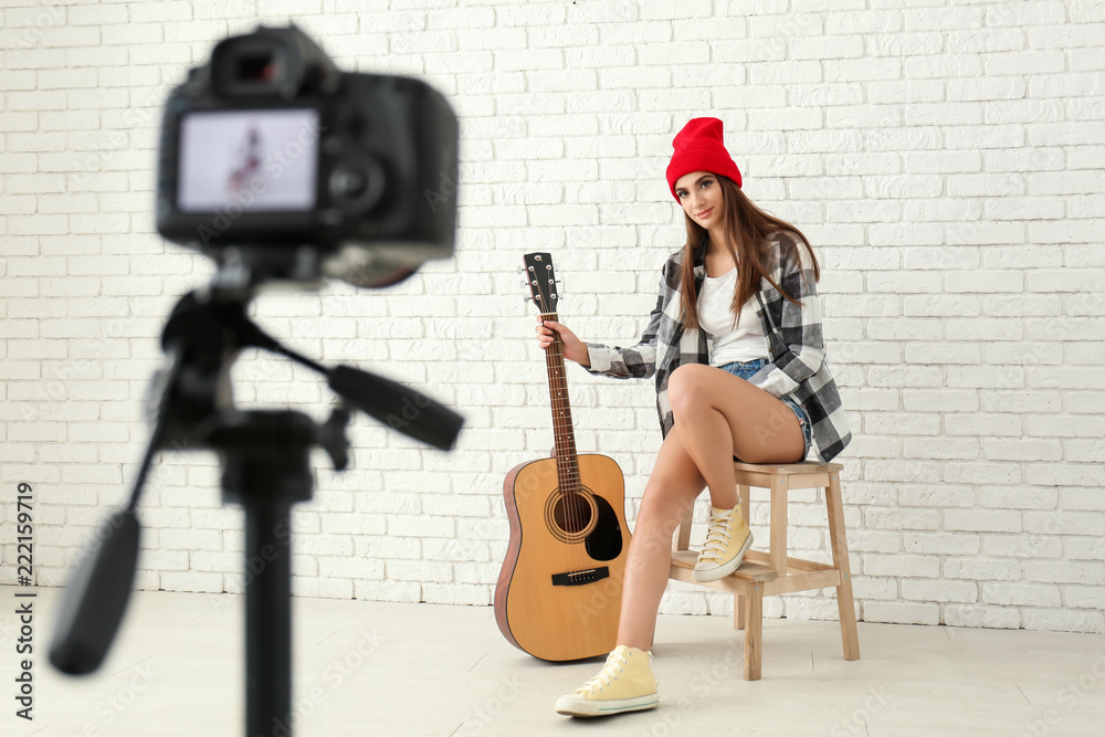 Fototapeta premium Young female musician recording video indoors
