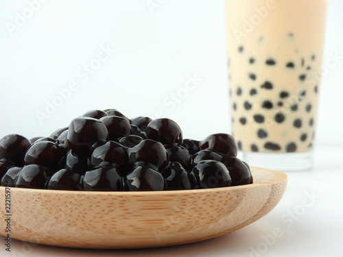 A glass cup of pearl milk tea (also called bubble tea) and a plate of tapioca ball on white background. Pearl milk tea is the most representative drink in Taiwan. Taiwan food . With copy space.
