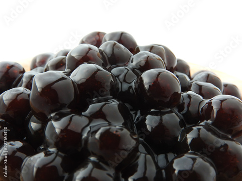 Front view and close up of black tapioca ball (also known as boba in bubble tea) which is ingredients for making pearl milk tea, other Taiwanese drink and shaved ice at dessert shop. Food background.