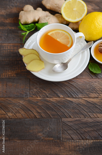 Ginger root tea with lemon and honey on wooden background, selective focus, copy space.