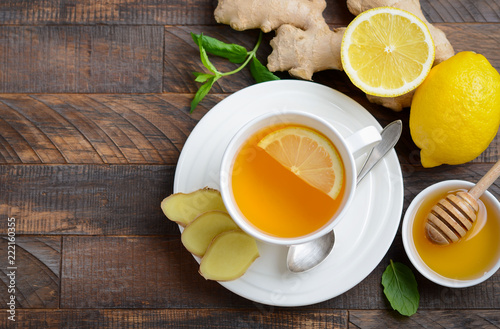 Obraz na płótnie Ginger root tea with lemon and honey on wooden background, top view, copy space