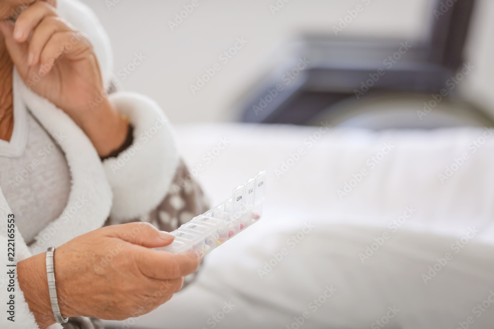 Senior woman with medicines at home, closeup