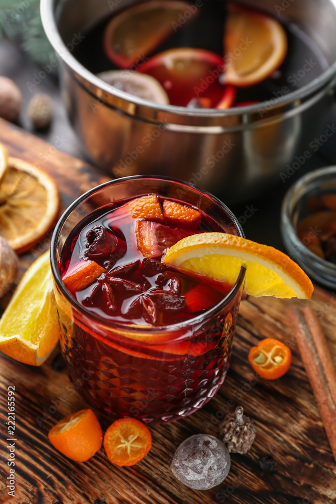 Glass of delicious mulled wine on wooden board Glass of delicious mulled wine on wooden board