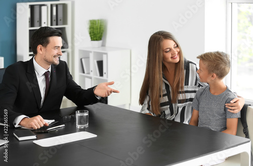Young woman and her son meeting with headmaster at school