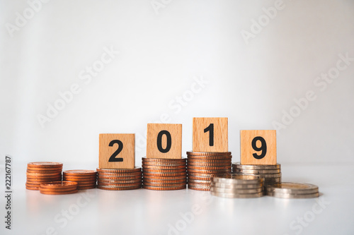 Wooden block year 2019 on stack coins using as business and financial concept